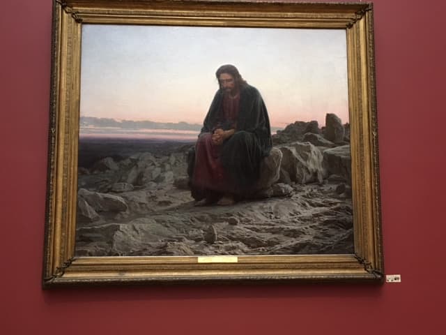 Ivan Kramskoi’s Christ in the Desert, 1872, hanging on a red wall in the Tretyakov Gallery.