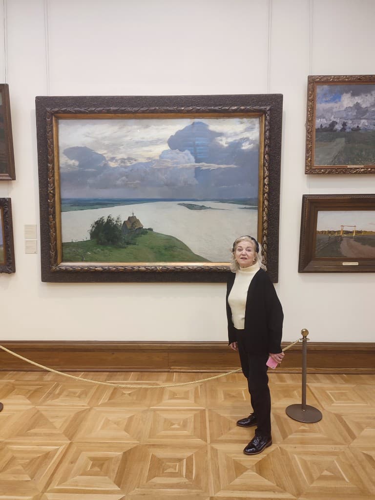 Francesca de Bardin standing beside Isaac Levitan’s At The Eternal Peace, 1894, in the Tretyakov Gallery.